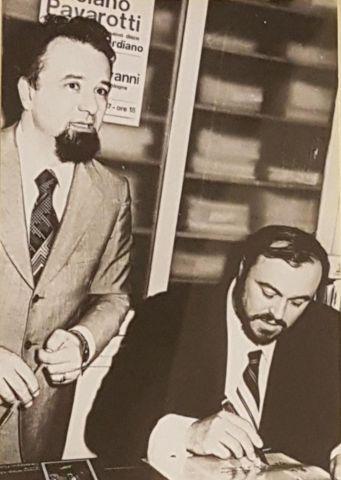 Il tenore Luciano Pavarotti firma il suo ultimo successo nel negozio Bongiovanni. Accanto a lui, Giancarlo Bongiovanni, fine anni settanta