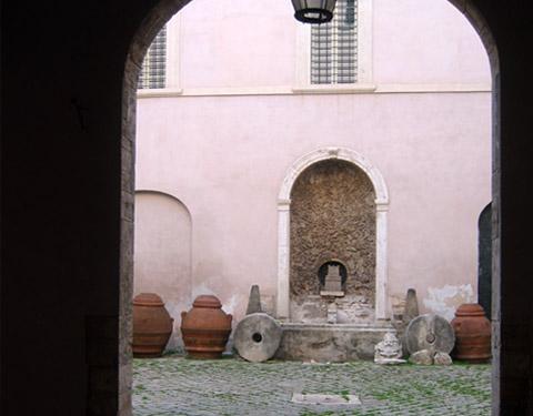 Vista del cortile di Palazzo Possenti Castelli con vettine e due antiche molazze in pietra