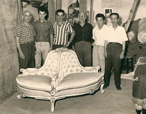Tappezzieri e fustai artigiani mostrano un divano modello sultana appena realizzato (1960 circa)