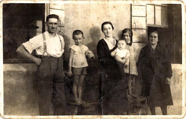 Vittorio Ferraretto con la famiglia. Alle spalle di Vittorio si intravede un macchinario utilizzato nell'officina, 1934 ca.