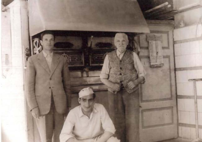 Giuseppe Garbellini, il fondatore del forno, insieme al figlio e a un lavorante davanti al forno e alla camera di lievitazione